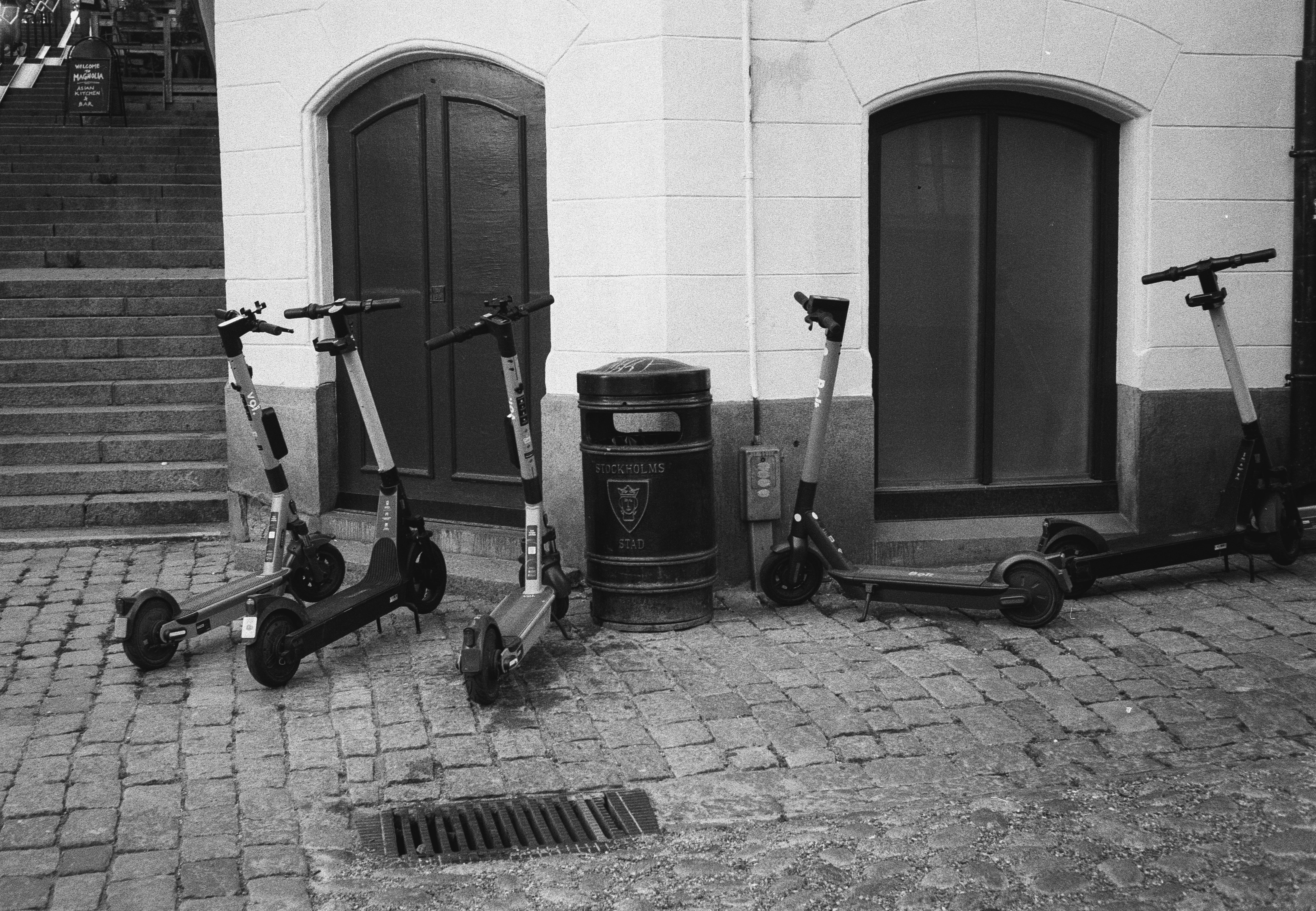 black and gray kick scooter beside black wooden door